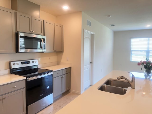 2569 Trinidad Rd, Haines City, FL 33844 - kitchen featuring appliances with stainless steel finishes, gray cabinetry, a sink, light countertops, and recessed lighting