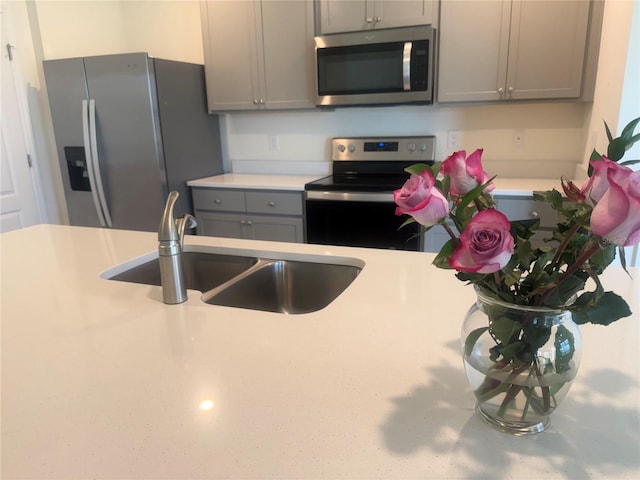 2569 Trinidad Rd, Haines City, FL 33844 - kitchen with stainless steel appliances, a sink, light countertops, and gray cabinets