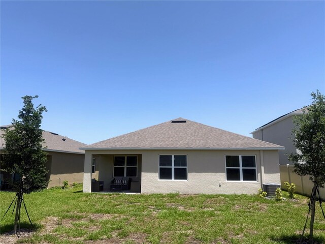 2569 Trinidad Rd, Haines City, FL 33844 - rear view of house with cooling unit, stucco siding, and roof with shingles
