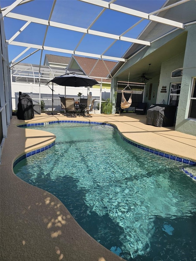 view of swimming pool featuring a patio, ceiling fan, outdoor dining space, and a lanai