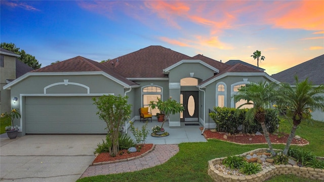 12445 Bohannon Blvd, Orlando, FL 32824 - mediterranean / spanish home featuring stucco siding, an attached garage, and driveway