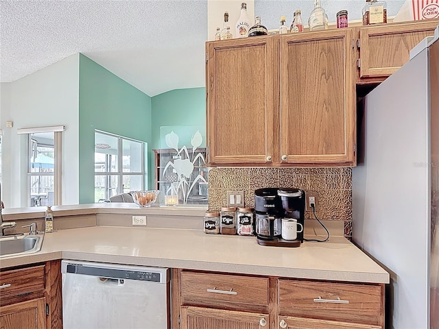 12445 Bohannon Blvd, Orlando, FL 32824 - kitchen with dishwasher, freestanding refrigerator, light countertops, decorative backsplash, and a textured ceiling