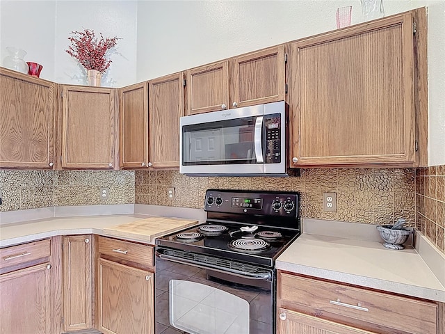 12445 Bohannon Blvd, Orlando, FL 32824 - kitchen featuring stainless steel microwave, black electric range oven, light countertops, and backsplash
