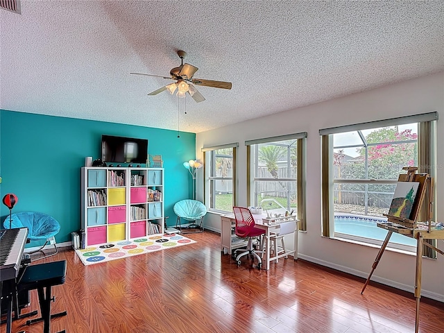 12445 Bohannon Blvd, Orlando, FL 32824 - rec room with a textured ceiling, a desk, ceiling fan, wood finished floors, and baseboards