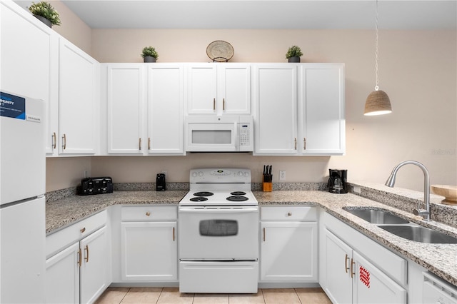 kitchen featuring white appliances, a sink, white cabinetry, and light tile patterned flooring