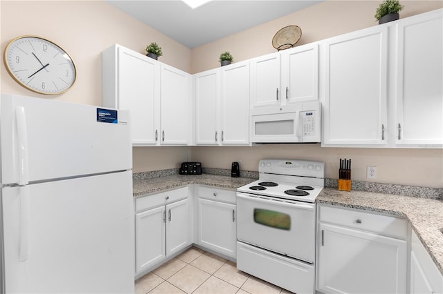 kitchen with white appliances, white cabinets, and light tile patterned flooring