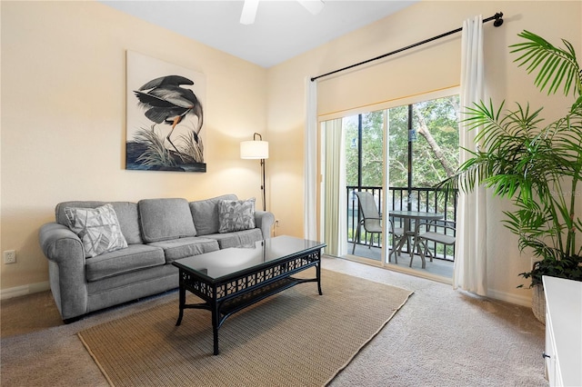 living room featuring carpet floors, baseboards, and ceiling fan