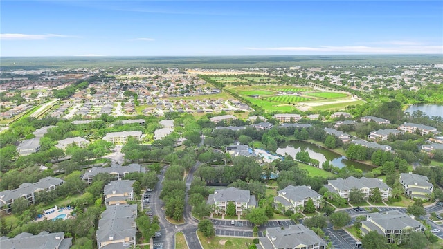 aerial view of property and surrounding area featuring nearby suburban area and a nearby body of water