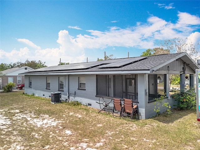 320 S Seminole Ave, Lake Alfred, FL 33850 - back of property featuring central AC unit, roof mounted solar panels, a shingled roof, and a sunroom