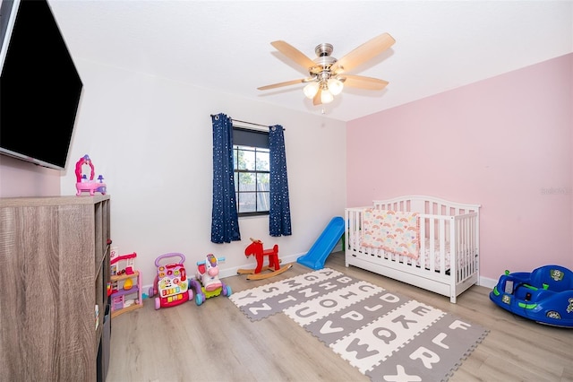 1730 Carolyn Ct, Saint Cloud, FL 34769 - bedroom with wood finished floors, a crib, ceiling fan, and baseboards