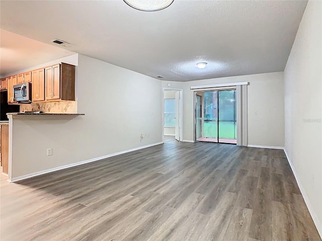 7865 Sugar View Ct Unit 7865, Orlando, FL 32819 - unfurnished living room featuring wood finished floors, a textured ceiling, and baseboards