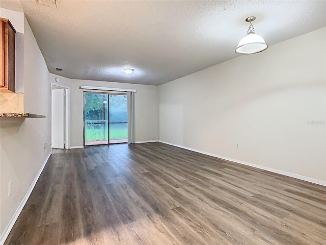 7865 Sugar View Ct Unit 7865, Orlando, FL 32819 - empty room featuring a textured ceiling, dark wood-style floors, and baseboards