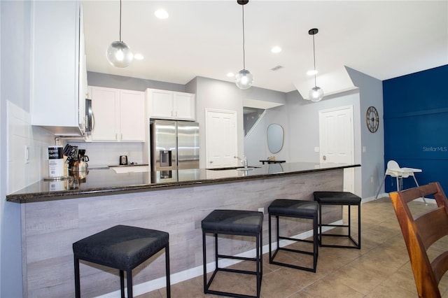 3181 Tocoa Cir, Kissimmee, FL 34746 - kitchen featuring appliances with stainless steel finishes, a sink, white cabinets, a peninsula, and dark stone countertops