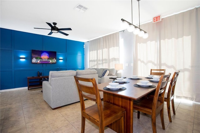 3181 Tocoa Cir, Kissimmee, FL 34746 - dining space featuring ceiling fan, light tile patterned floors, and a decorative wall