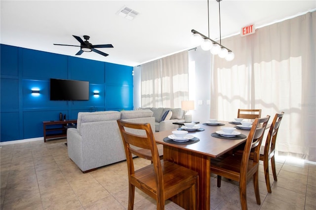 3181 Tocoa Cir, Kissimmee, FL 34746 - dining room featuring a ceiling fan, light tile patterned floors, and a decorative wall