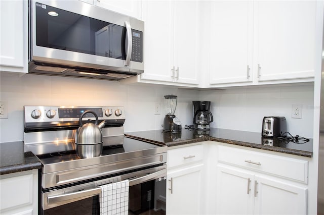 3181 Tocoa Cir, Kissimmee, FL 34746 - kitchen with appliances with stainless steel finishes, tasteful backsplash, and white cabinets
