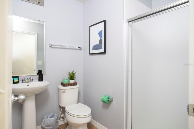 3181 Tocoa Cir, Kissimmee, FL 34746 - bathroom featuring toilet, a shower with door, and baseboards