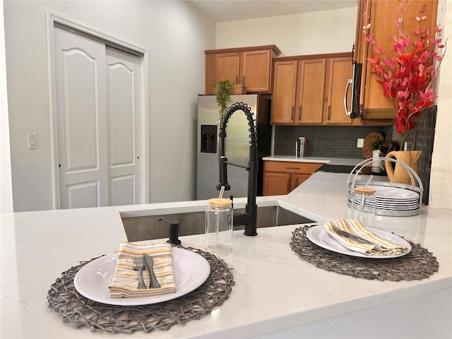 10734 Dawson Lily Way Unit S, Orlando, FL 32832 - kitchen featuring backsplash, brown cabinetry, light stone countertops, stainless steel microwave, and a sink