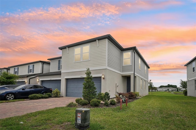 view of front of house with a garage, stucco siding, decorative driveway, and a front yard