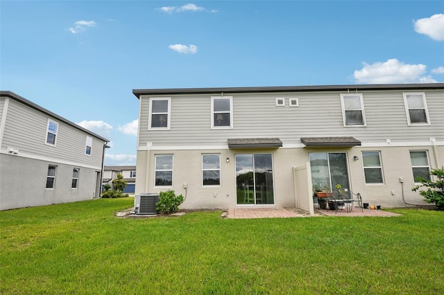 back of property with cooling unit, a yard, a patio, and stucco siding