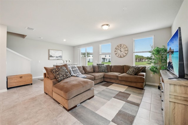 living area featuring light tile patterned floors, healthy amount of natural light, and baseboards