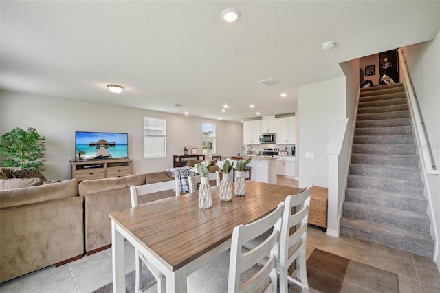 dining room with stairs, light tile patterned flooring, and recessed lighting