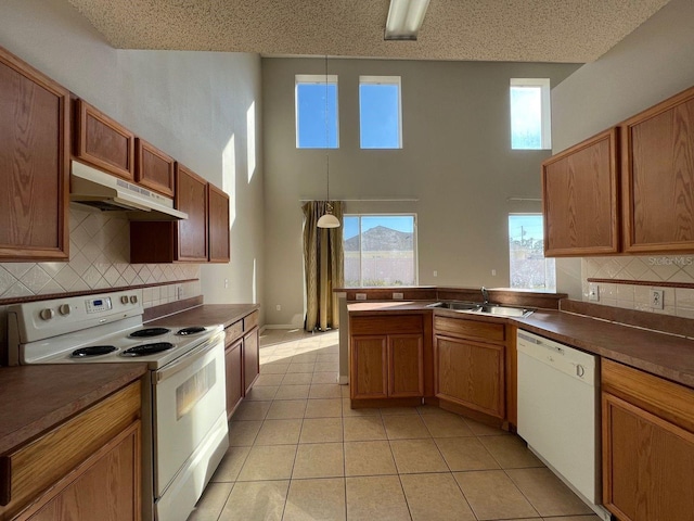 340 Cimarron Ct, Poinciana, FL 34759 - kitchen featuring white appliances, under cabinet range hood, a sink, light tile patterned floors, and decorative backsplash