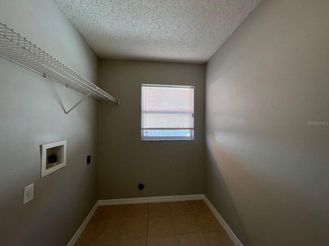 340 Cimarron Ct, Poinciana, FL 34759 - washroom featuring hookup for an electric dryer, washer hookup, tile patterned flooring, a textured ceiling, and baseboards