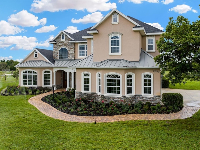 2350 Bradbury Rd, Haines City, FL 33844 - view of front of house featuring a standing seam roof, stucco siding, stone siding, and a front lawn