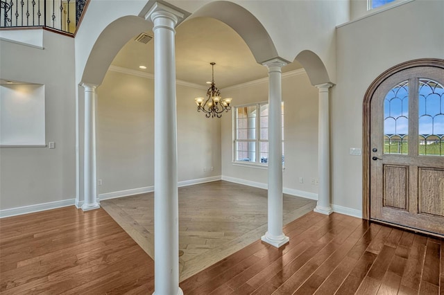 2350 Bradbury Rd, Haines City, FL 33844 - foyer entrance with wood finished floors, crown molding, arched walkways, baseboards, and a chandelier