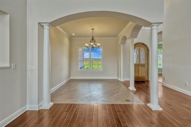 2350 Bradbury Rd, Haines City, FL 33844 - unfurnished dining area featuring dark wood-type flooring, arched walkways, crown molding, baseboards, and a chandelier