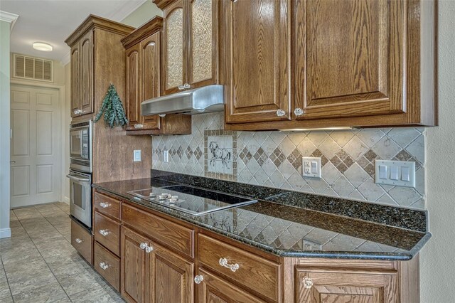2350 Bradbury Rd, Haines City, FL 33844 - kitchen featuring appliances with stainless steel finishes, under cabinet range hood, tasteful backsplash, and brown cabinets