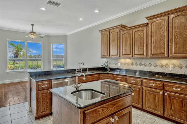 2350 Bradbury Rd, Haines City, FL 33844 - kitchen with a sink, dark stone counters, a peninsula, a ceiling fan, and crown molding