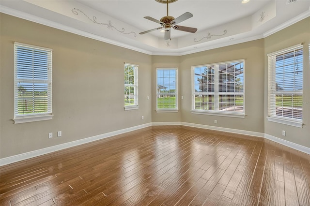 2350 Bradbury Rd, Haines City, FL 33844 - empty room with a raised ceiling, hardwood / wood-style flooring, ceiling fan, plenty of natural light, and crown molding