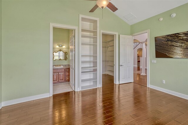 2350 Bradbury Rd, Haines City, FL 33844 - unfurnished bedroom with arched walkways, vaulted ceiling, a spacious closet, wood finished floors, and a closet