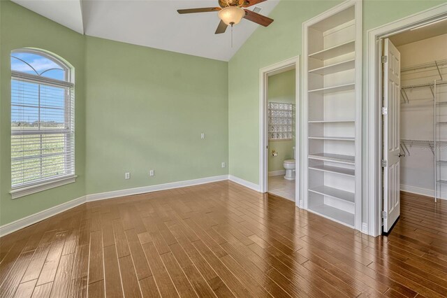 2350 Bradbury Rd, Haines City, FL 33844 - unfurnished bedroom featuring a walk in closet, wood finished floors, a closet, baseboards, and high vaulted ceiling