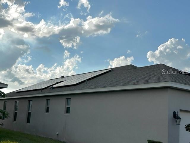 9318 Mclaren Aly, Winter Garden, FL 34787 - view of side of property with stucco siding, solar panels, and roof with shingles