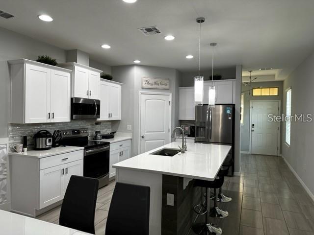 9318 Mclaren Aly, Winter Garden, FL 34787 - kitchen with stainless steel appliances, a sink, tasteful backsplash, light countertops, and recessed lighting