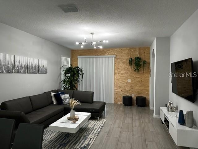 9318 Mclaren Aly, Winter Garden, FL 34787 - living room with a chandelier, wood tiled floors, and a textured ceiling
