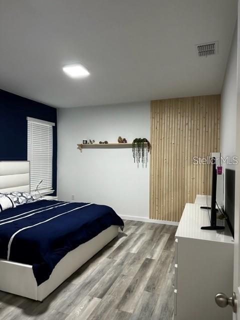 9318 Mclaren Aly, Winter Garden, FL 34787 - bedroom with wood finished floors and wood walls