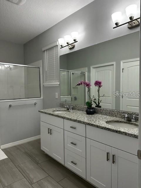 9318 Mclaren Aly, Winter Garden, FL 34787 - bathroom with a stall shower, double vanity, and a textured ceiling