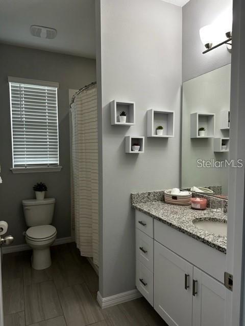 9318 Mclaren Aly, Winter Garden, FL 34787 - bathroom with toilet, vanity, and baseboards