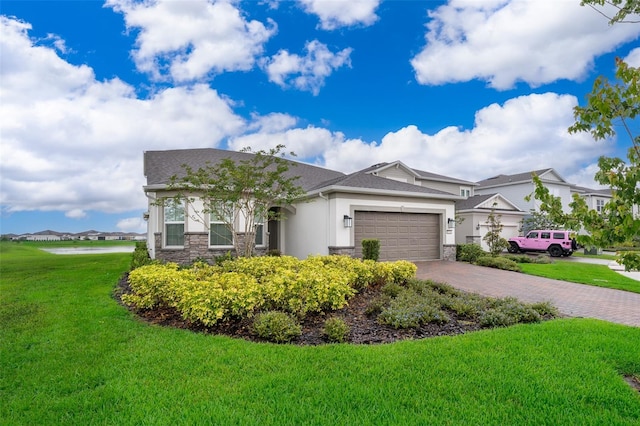 view of front of home featuring an attached garage, stone siding, stucco siding, decorative driveway, and a front lawn