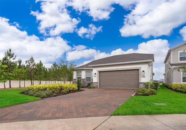 view of front of house featuring decorative driveway, stucco siding, stone siding, and a garage