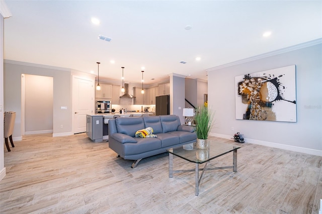 living area with ornamental molding, baseboards, light wood-style flooring, and recessed lighting