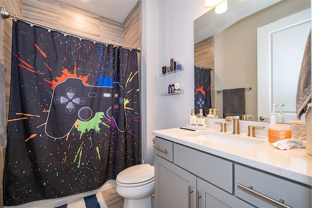 full bathroom with toilet, vanity, and curtained shower