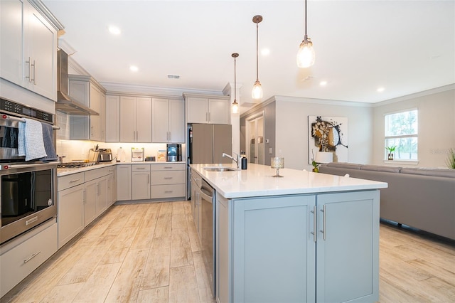 kitchen with appliances with stainless steel finishes, gray cabinetry, a sink, light wood-type flooring, and crown molding