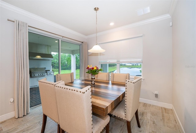 dining area with light wood-style flooring, baseboards, and ornamental molding