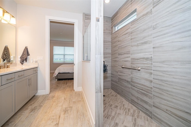 ensuite bathroom with walk in shower, healthy amount of natural light, vanity, recessed lighting, and baseboards