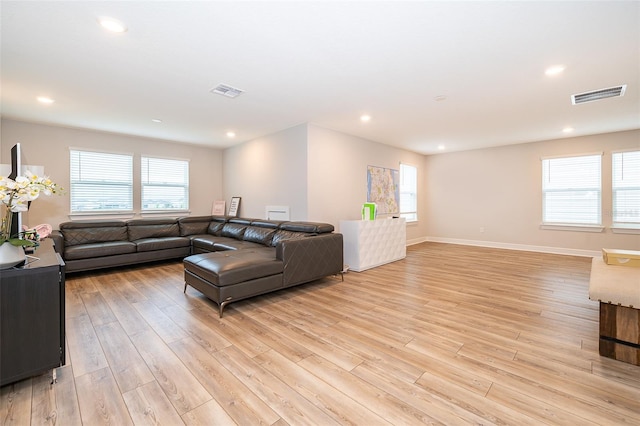 living room with light wood-style floors, healthy amount of natural light, recessed lighting, and baseboards